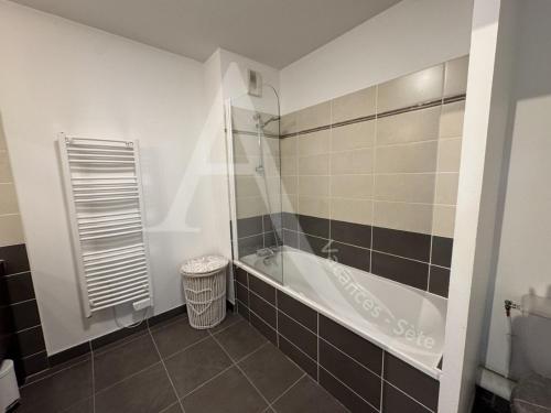 une salle de bain avec baignoire et toilettes dans l'établissement 3 CHAMBRES TOUT CONFORT EN BORD DE MER, à Sète