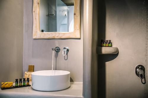 a bathroom with a white sink and a mirror at Kalisti Hotel & Suites in Fira