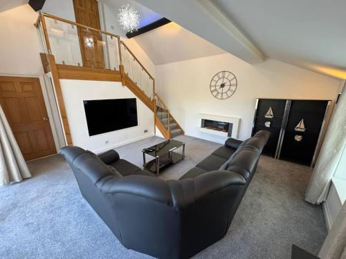 a living room with a couch and a tv at Castle House Holiday Home in Chapel en le Frith