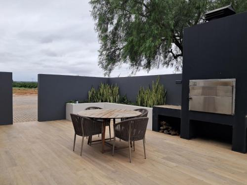 a table and chairs on a patio with a wall at Addo Park Suma's Rest in Addo