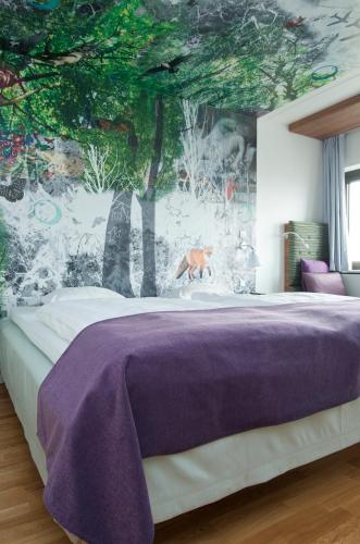 a bedroom with a bed with a tree mural on the wall at Scandic Copenhagen in Copenhagen