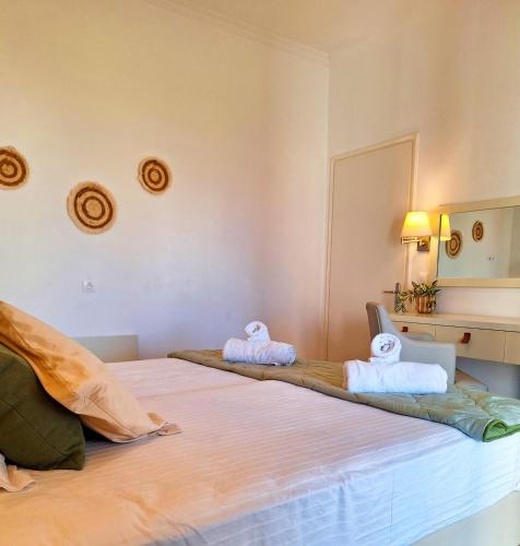 two beds in a room with towels on them at Ever Green beach Apartments in Kavos
