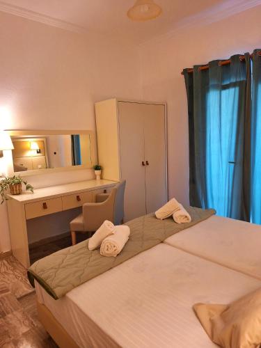 a hotel room with two beds and a desk and a mirror at Ever Green beach Apartments in Kavos