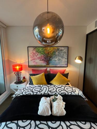 a bedroom with a bed with two white shoes on it at The Atrium - Olympic Park 50m to ACCOR FREE PARK in Sydney