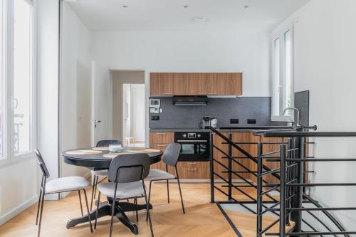 une cuisine et une salle à manger avec une table et des chaises dans l'établissement Elegant Parisian Apartment near Eiffel Tower, à Paris