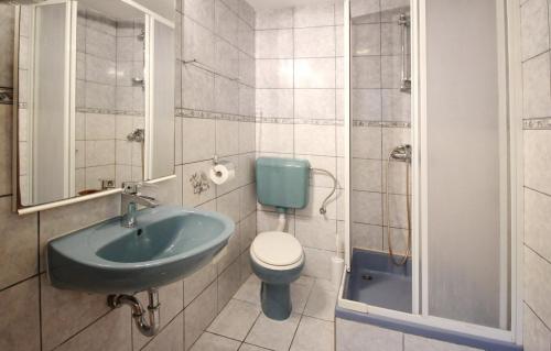 un bagno con lavandino, WC e doccia di Apartments Mikulan Beach a Baška