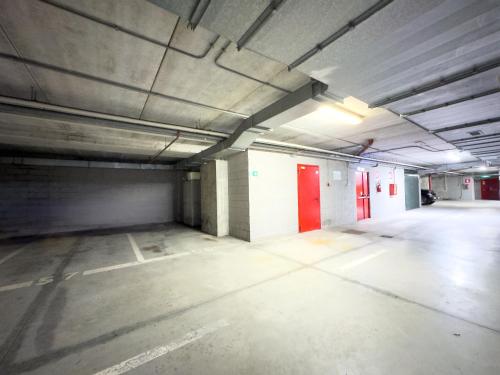 an empty parking lot with red doors in a parking garage at Attico Centro con terrazza e jacuzzi e parcheggio privati in Genova