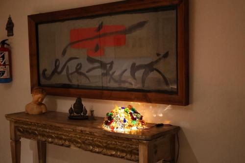 a table in a room with a painting on the wall at El Cedre Blau Vivienda con piscina en Granollers in Granollers