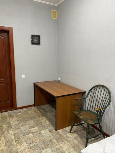 a desk and a chair in a room at Момент in Yuzhnoukrainsk 