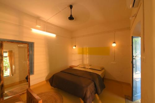 a small bedroom with a bed and a window at Haust in Varkala