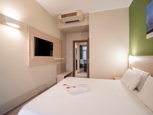 a bedroom with a white bed and a television at Best Quality Hotel Gran Mogol in Turin