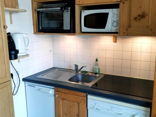 une cuisine avec un évier et un micro-ondes dans l'établissement Spacieux Duplex 3 Pièces aux Deux Alpes, Pied des Pistes, Parking Privatif - FR-1-516-168, à Les Deux Alpes