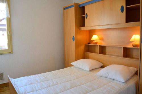 une chambre avec un lit avec deux oreillers dans l'établissement Appart 2 pièces 4 couchages PORT LEUCATE NATURISME PL010-843, à Port-Leucate