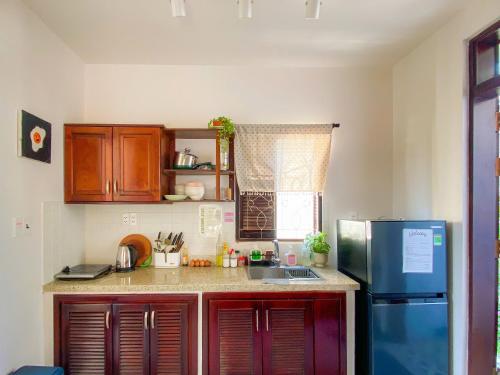 a small kitchen with a refrigerator and a sink at DƯỚI TÁN CÂY homestay in Tây Ninh