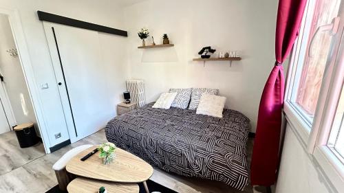 une petite chambre avec un lit et une table dans l'établissement Studio cosy Aix les Bains, à Aix-les-Bains