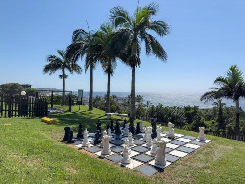 a chess board on a lawn with palm trees at Ballito Bliss Chalet at Chaka's Rock Chalets 9 in Ballito