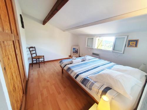 a bedroom with a bed and a chair in it at Maison typique corse pour 4 personnes in Zonza