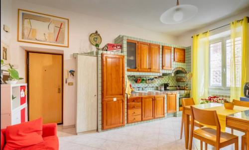 a kitchen with wooden cabinets and a table and chairs at Stanza Valentina vicino Torvergata in Rome