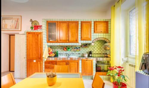 a kitchen with wooden cabinets and a table at Stanza Valentina vicino Torvergata in Rome