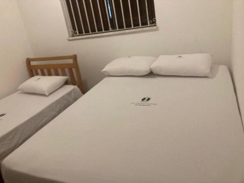 Dos camas individuales en una habitación con ventana. en Leme Apartamento 1 quadra da Praia, en Río de Janeiro