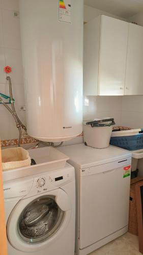 a kitchen with a washing machine and a washer at Pareada con piscina privada y con vistas in Comarruga