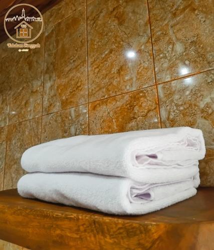 a pile of towels sitting on a table in a bathroom at ndalem singgah malioboro by abiza in Demangan