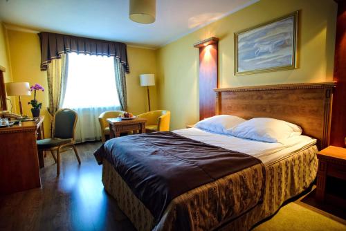 a hotel room with a bed and a window at Hotel Pietrak in Wągrowiec