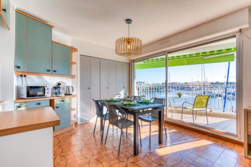 une cuisine et une salle à manger avec une table et des chaises dans l'établissement Marina Port Camargue, au Grau-du-Roi