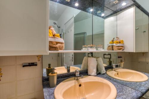 une salle de bain avec deux lavabos et un grand miroir dans l'établissement Marina Port Camargue, au Grau-du-Roi