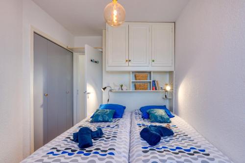 une chambre avec un lit avec des oreillers bleus dans l'établissement Marina Port Camargue, au Grau-du-Roi