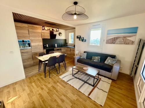 un salon avec un canapé et une table dans l'établissement Appartement pleine vue mer à 50m de la plage, à Villers-sur-Mer