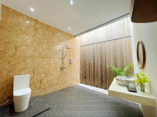a bathroom with a shower and a toilet and a sink at ndalem singgah malioboro by abiza in Demangan
