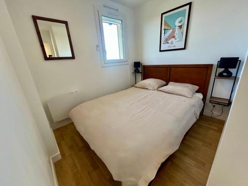 une chambre avec un grand lit avec deux oreillers dans l'établissement Appartement pleine vue mer à 50m de la plage, à Villers-sur-Mer