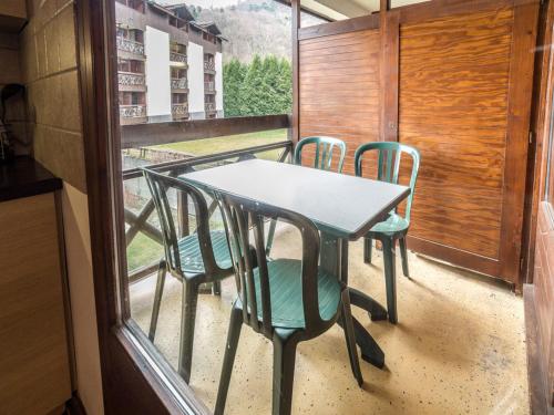 une table et des chaises sur un balcon avec une fenêtre dans l'établissement Studio accueillant avec balcon, parking et wifi - Brides-les-Bains - FR-1-512-250, à Brides-les-Bains