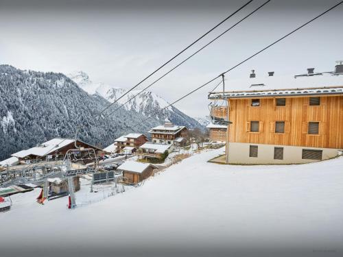 a ski resort with a ski lift in the snow at Penthouse Barbossine - OVO Network in Châtel