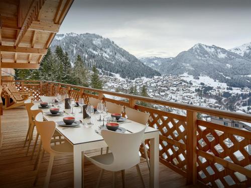 a restaurant with tables and chairs on a balcony with mountains at Penthouse Barbossine - OVO Network in Châtel