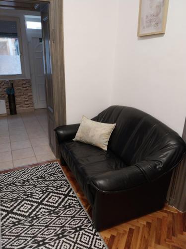 a black leather couch sitting in a living room at Repi-Tár apartman in Szolnok