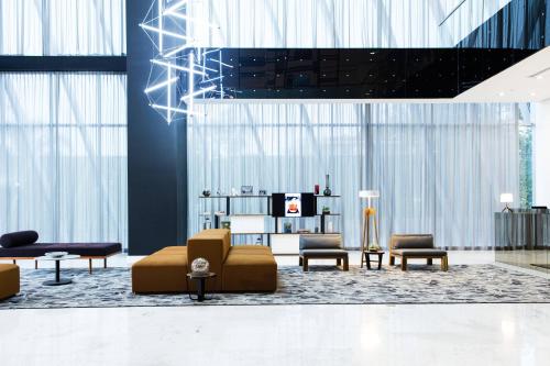 a lobby with couches and chairs in a building at AC Hotel by Marriott Guadalajara Mexico in Guadalajara
