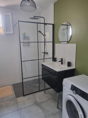 une salle de bain avec un lavabo et une machine à laver dans l'établissement Maison proche plage, à Merlimont