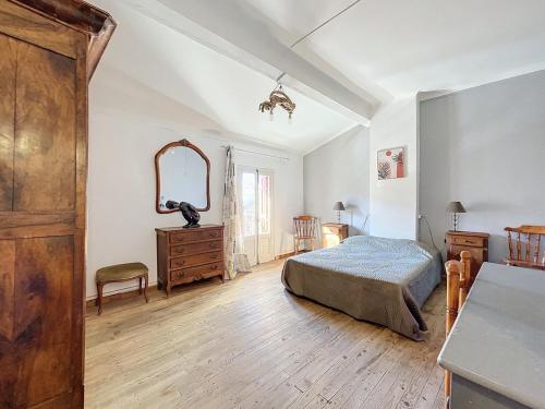 une chambre avec un lit, une commode et un miroir dans l'établissement 3473-Maison 6 couchages, à Villelongue-dels-Monts