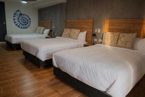 a hotel room with two beds with white sheets at Narea San Bartolo in San Bartolo