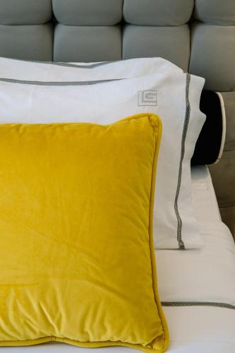 a yellow pillow sitting on top of a bed at Kalisti Hotel & Suites in Fira