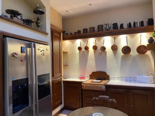 een keuken met een koelkast en wat potten en pannen bij Le rêve de Jocelyne - Grande maison au Neubourg in Le Neubourg