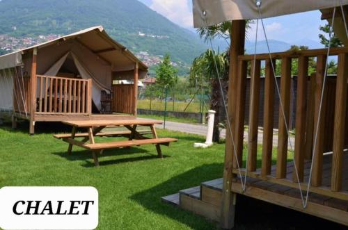 a cabin with a picnic table and a gazebo at Glamping Italia 90 Mini Lodges in Domaso