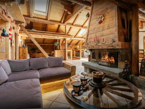 un salon avec un canapé et une cheminée dans l'établissement La Ferme à Juju - OVO Network, à La Clusaz