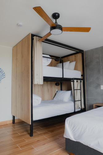 two bunk beds in a room with a ceiling fan at Narea San Bartolo in San Bartolo