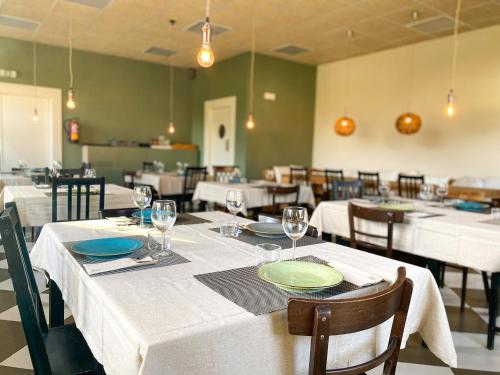 a dining room with white tables and chairs at Parcelas Chill-Outdoor in Perarrua