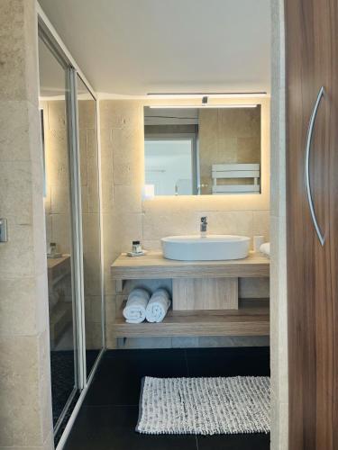 une salle de bain avec un lavabo et un miroir dans l'établissement Villa Azur Golf, à Bandol