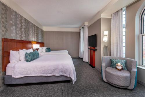 a hotel room with a bed and a chair at Courtyard Boston Copley Square in Boston