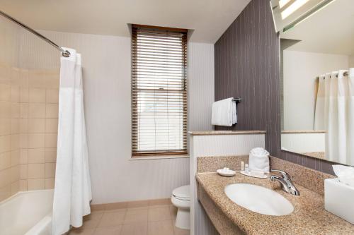 a bathroom with a sink and a toilet and a tub at Courtyard Boston Copley Square in Boston